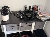 un bureau sur lequel sont posés plusieurs sèche-cheveux et d'autres objets