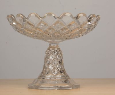 a glass bowl on a table with a white wall in the background