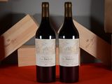 two bottles of wine sitting next to each other on a table