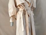 une photo d'un mannequin vêtu d'un trench-coat, posé sur un pied de mannequin
