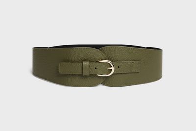 une femme portant une ceinture en cuir verte avec une boucle dorée