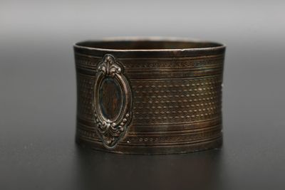 un gros plan d'une bague posée sur une table, sur fond gris