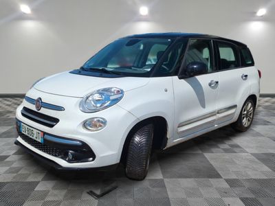 la petite voiture blanche est garée sur un sol en damier