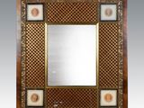 un grand miroir avec un cadre en bois et un motif décoratif
