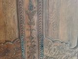 a wooden cabinet with carvings on it in a room