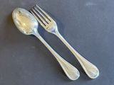 two silver spoons and a fork on a table