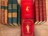 plusieurs vieux livres posés sur une table en bois, avec une couverture rouge