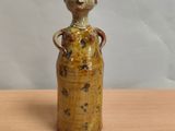 un petit vase orné d'un singe, posé sur une table