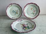 trois assiettes à motifs floraux posées sur une table