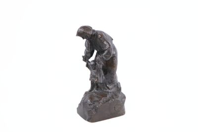 statue of a man holding a bird on a rock