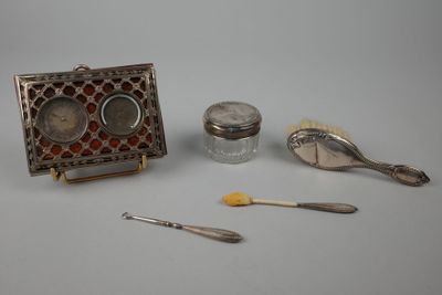 une boîte en argent, des cuillères et d'autres objets posés sur une table