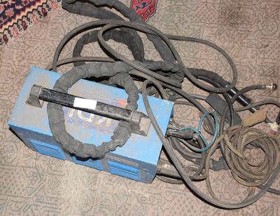 une boîte bleue avec tout un tas de fils, posée par terre