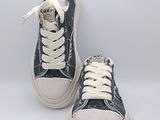 une paire de baskets noires et blanches avec des lacets blancs sur fond blanc