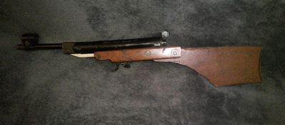 le fusil est posé sur le tapis, à côté du pistolet