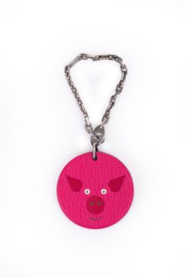 porte-clés en cuir rose avec une tête de cochon suspendue à une chaîne