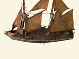 a small model of a sailboat on a white surface