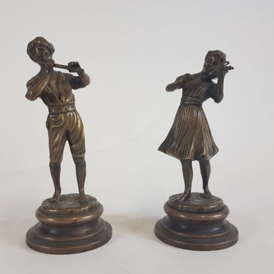 paire de figurines en bronze représentant un homme et une femme jouant de la flûte