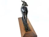 a statue of a goat that is on a wooden stand