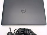 dell laptop with power cord and charger on a white surface