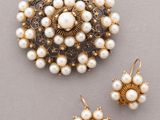 a close up of a brooch and earrings on a table