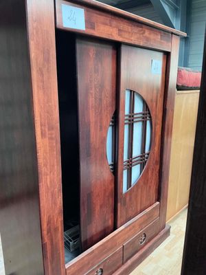 une image d'une armoire en bois avec une porte en verre