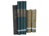 several books are stacked on top of each other on a white surface