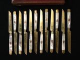 several knives are lined up in a row next to a book