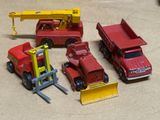 quatre camions miniatures rangés les uns à côté des autres