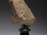 a stone head on a pedestal with a black base