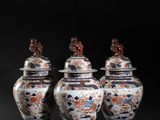 three chinese vases with lids are sitting on a black surface