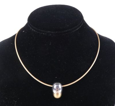 un collier en or orné d'une perle de verre autour du cou d'un mannequin