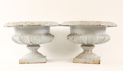 two white vases sitting next to each other on a white surface