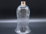 a clear glass bottle with a gold lid on a table