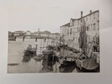 a black and white photo of a harbor with boats