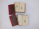 three old books sitting on top of a white table next to each other