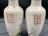 two white vases with asian writing on them sitting on a table