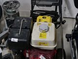 two lawn mowers sitting next to each other on the floor
