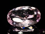 gros plan d'un diamant rose sur une surface noire
