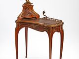 a small desk with a clock on top of it