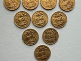 a close up of a bunch of gold coins on a white surface