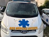 a white van parked in front of a building with an ambulance sign on it