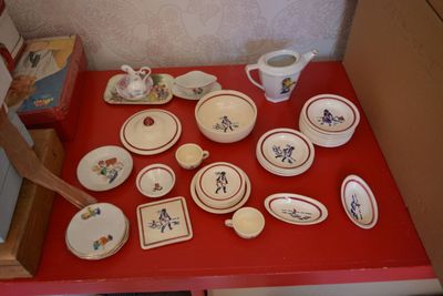 une table rouge sur laquelle sont posés des assiettes et des bols