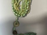 un collier orné de perles et d'un pompon qui y est suspendu