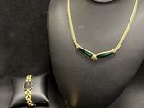 a necklace, bracelet, and ring are on display on a mannequin