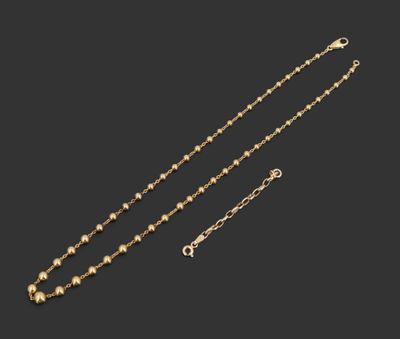 un collier en or et une paire de boucles d'oreilles sur fond noir