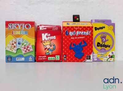 Trois boîtes de jeux pour enfants sont alignées sur une table