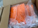 a box of carrots wrapped in plastic on the ground
