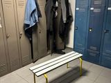 un banc au milieu d'une pièce, avec des casiers en arrière-plan