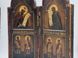three wooden panels with paintings of saints on them on a white surface