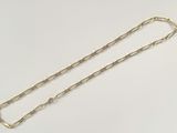 a close up of a gold chain on a white surface